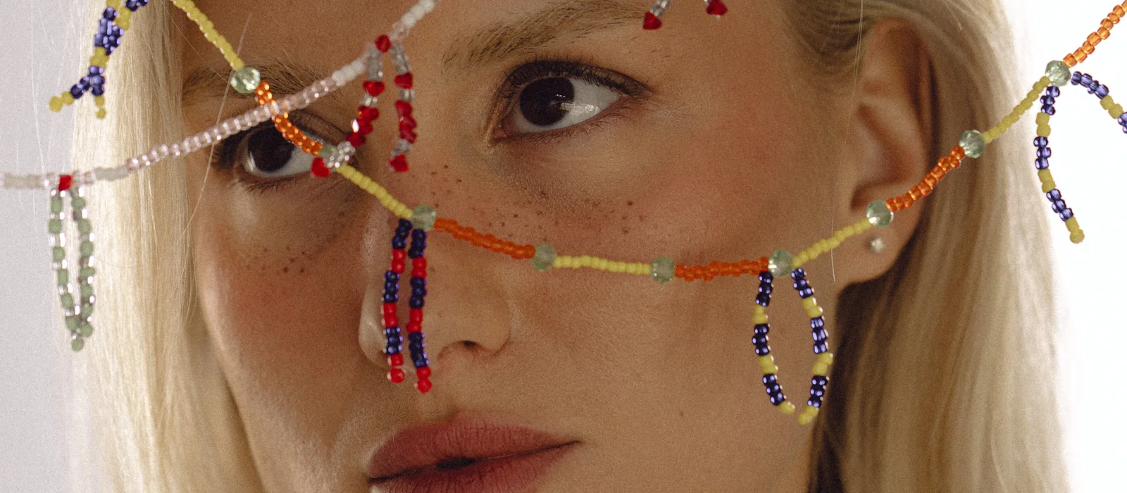 a model wearing strands of colourful glass beads